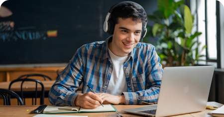 Student with headphones studying on laptop